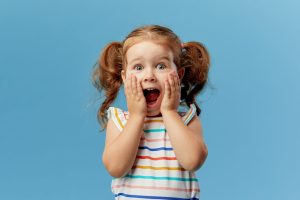 Portrait of surprised cute little toddler girl child standing is